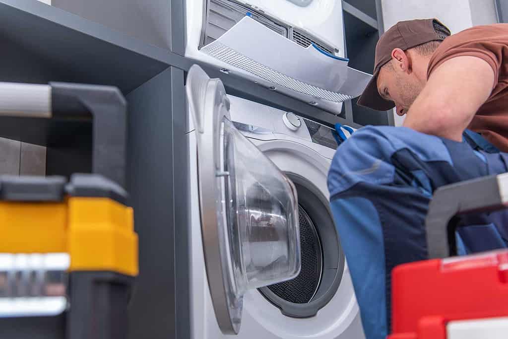 Washer repair Mississauga - man repairing a washer - Dial An Applianceman