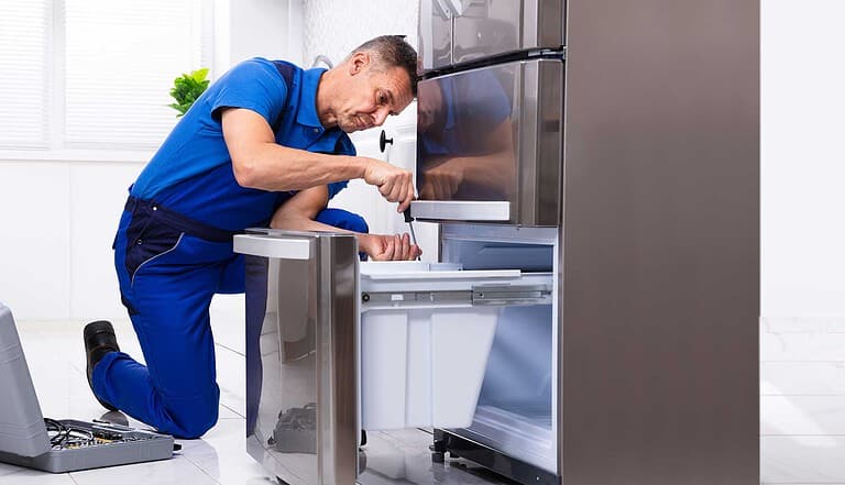 appliance repair mississauga - man repairing a freezer